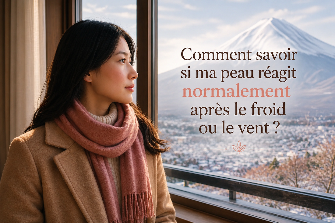 Femme japonaise devant une fenêtre avec vue sur le mont Fuji enneigé, observant sa peau après une exposition au froid, illustrant les réactions normales de la peau au vent et aux basses températures.