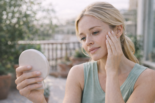 femme blonde observant la peau de son visage illustrant l evolution irreguliere de la peau et les cycles biologiques cutanes