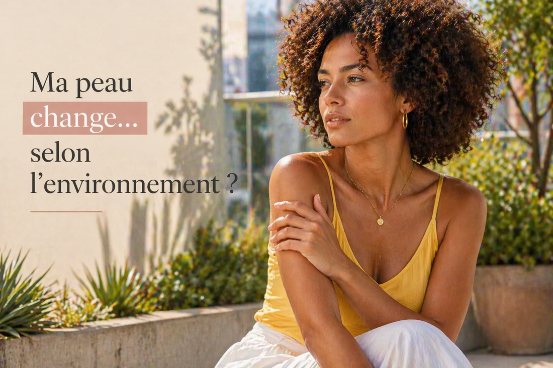 Femme métisse aux cheveux afro observant sa peau en extérieur dans un jardin urbain, illustrant les variations de la peau selon l’environnement
