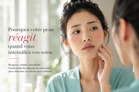 Femme asiatique observant une légère rougeur sur sa peau dans une salle de bain lumineuse illustrant une peau du visage qui devient plus réactive lorsque les soins sont intensifiés.