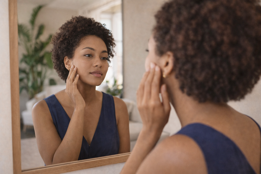 femme afro descendant observant différentes zones du visage dans un miroir evolution peau